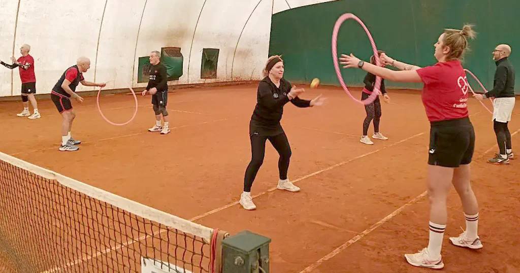 una serie di allievi di tennis che si allenano